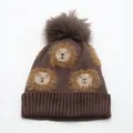 Dettaglio del cappello in maglia marrone per bambini con motivi di leone e pompon soffice - Taglia unica (Bambini) / caffè