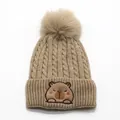 Dettaglio del berretto in maglia kaki con pompon soffice e patch capibara ricamata - Taglia unica / Cachi