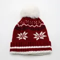 Dettaglio del berretto in maglia invernale con pompon bianco e motivi a fiocchi di neve - Taglia Unica Elastica (3-10 Anni) / Rosso