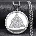 Macro shot of silver trinity knot pendant with crystal inlay and spiritual engravings - Silver