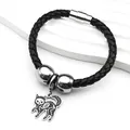 Primer plano de pulsera de cuero trenzado negro con cierre magnético y colgante de gato calavera - Plateado