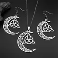 Macro view of silver Celtic crescent moon necklace and hook earrings set on black surface - Silver Necklace And Earrings