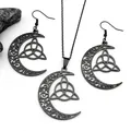 Detailaufnahme von schwarzem keltischem Dreifaltigkeitsknoten und Mondschmuck-Set auf Stein - Schwarz Halskette Und Ohrringe