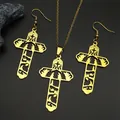 Makro-Detail von goldenem Edelstahl-Kreuz-Schmuckset mit hohlgearbeitetem Krippen-Design - Goldenes Set