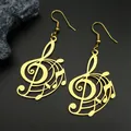 Macro detail of gold treble clef musical note earrings on black textured surface - Gold Ear Hook
