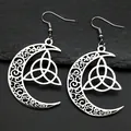 Macro shot of silver crescent moon earrings with intricate Celtic Triquetra knot design - Silver Earrings