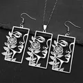 Gros plan d'un pendentif rectangulaire argenté avec portrait évidé et motif de rose - Ensemble collier et boucles d'oreilles / Parure de Bijoux en Argent