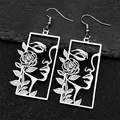 Gros plan de boucles d'oreilles argentées ajourées avec portrait et rose sur roche - Boucles d'oreilles / Crochets d'Oreilles Argentés