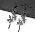 Détail macro de boucles d'oreilles roses en acier inoxydable noir mat sur une pierre - Boucles d'oreilles noires