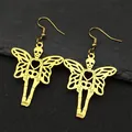 Golden skeleton butterfly wing earrings with heart cutout on dark stone background - Hook Earrings / Gold