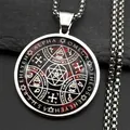 Gros plan d'un collier amulette occulte circulaire en acier titane sur roche noire - Argent