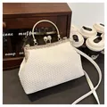 Clutch da sera intrecciata bianca con chiusura di perle, dettagli oro e cornice strass - Bianco