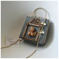 Detail of gray leather bag with angel relief, gold handle, and pearl chain strap - Angel Version / Gray