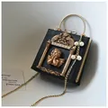 Macro shot of vintage black crossbody bag with baroque angel relief and gold metal handle - Angel Version / Black