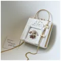 Detail of white square bag featuring angel relief, rose frame, and pearl pendant accent - Angel Version / White