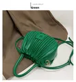 Nahaufnahme der plissierten grünen PU-Handtasche auf einem braunen Blazer im Lifestyle-Set - Grün