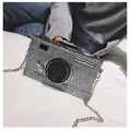 Close-up of a silver sequin camera-shaped crossbody bag with gold star details and metal chain - Silver