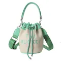 Straw bucket bag in light beige with mint green trim and THE BUCKET embroidery - Dark Green