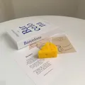 Realistic cheese shaped soy wax scented candle on a desk with artistic books - Cheese