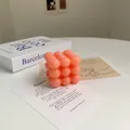 Gros plan d'une bougie cube à bulles rose avec mèche blanche et surface texturée - Bubble Cube Rose Clair (Rose)