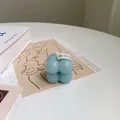 Macro shot of a light blue bubble cube scented candle with a white natural label tag - Small Blue Bubble Cube