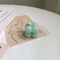 Macro shot of mint green bubble cube scented candle on an artistic Matisse card - Small Green Bubble Cube