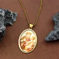 Gros plan du pendentif ovale doré de Saint Antoine avec icône religieuse sur chaîne - Or