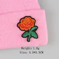 Rose embroidery patch on a pink knitted beanie with green leaves and black border detail - Orange-red Rose (GZ-4450)