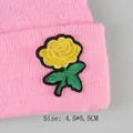 Gelbe Rose Stickerei-Aufnäher mit schwarzen Konturen auf einer rosa Strickmütze - Gelbe Rose (GZ-4446)