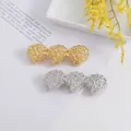 Vista de detalle de pinzas para el cabello en forma de concha dorada y plateada - Estilo Concha Dorada