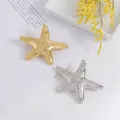 Macro detail of starfish shaped brooches with textured metallic dotted surface - Silver-Tone Starfish Style