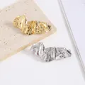 Vista macro de accesorios metálicos irregulares en oro y plata sobre una piedra - Estilo Texturizado Geométrico Tono Plateado 1