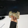 Primer plano del bolso de mano mariposa dorado con acabado espejo y cadena - Forma de Lazo / Dorado