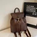 Brown vintage leather backpack with drawstring closure and golden hardware - Coffee