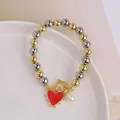 Detail of 18K gold plated OT clasp bracelet with red heart charm and pearl drop - Red