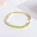 Detail of 18K gold-plated hinged bangle with vibrant neon green enamel stripes - Yellow