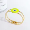Detail eines 18K vergoldeten Evil Eye Armreifs mit grünem Emaille und Parfümflasche - Gelb