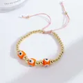 Detailed view of adjustable evil eye bracelet with gold copper beads and orange charms - Orange