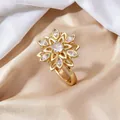 Eleganter goldener Blumenring mit rotierenden Blütenblättern und funkelnden Kristallen - Stahl Schneeflocke Rotierender Stil / Stahlfarben