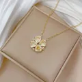 Close-up of heart-shaped zircon clover pendant on gold chain with silk backdrop - Heart Clover Style (X1509) / Lemon Yellow