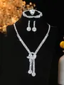 Macro detail of silver bridal jewelry set with sparkling tassels and crystal settings - Silver 3D Knot Tassel Necklace Bracelet Earrings Ring Set (PJ--T0239)