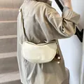 Chic beige crescent saddle bag with leather texture and brown pompom on shoulder - With Pendant / White