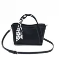 Black leather bucket bag with white stitching and a heart-patterned silk scarf handle - Black