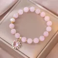 Dettaglio di perle in cristallo rosa con ciondolo a cuore e perla su un portagioie dorato - Stile Cuore Quarzo Rosa Perla d'Acqua Dolce (TS0338)