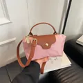 Mini pink and brown leather crossbody tote bag with adjustable strap in hand display - Pink with Brown