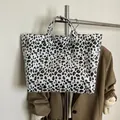 Grande borsa shopper leopardata con scritta bianca appesa a una gruccia d'argento - Bianco