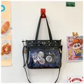Detail of a black PU ita bag featuring a large transparent window and heart-shaped buckles - Black