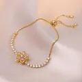 Elegant gold-tone spinning flower necklace with zircon petals on a silk background - White Bauhinia Bracelet