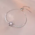 Detail eines verstellbaren Silberarmbands mit lila Blume und weißer Perle im Zentrum - Lila Silber Gänseblümchen Armband