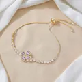 Elegant gold clover bracelet with purple heart crystals and clear zircon accents - Purple Rotating Bracelet